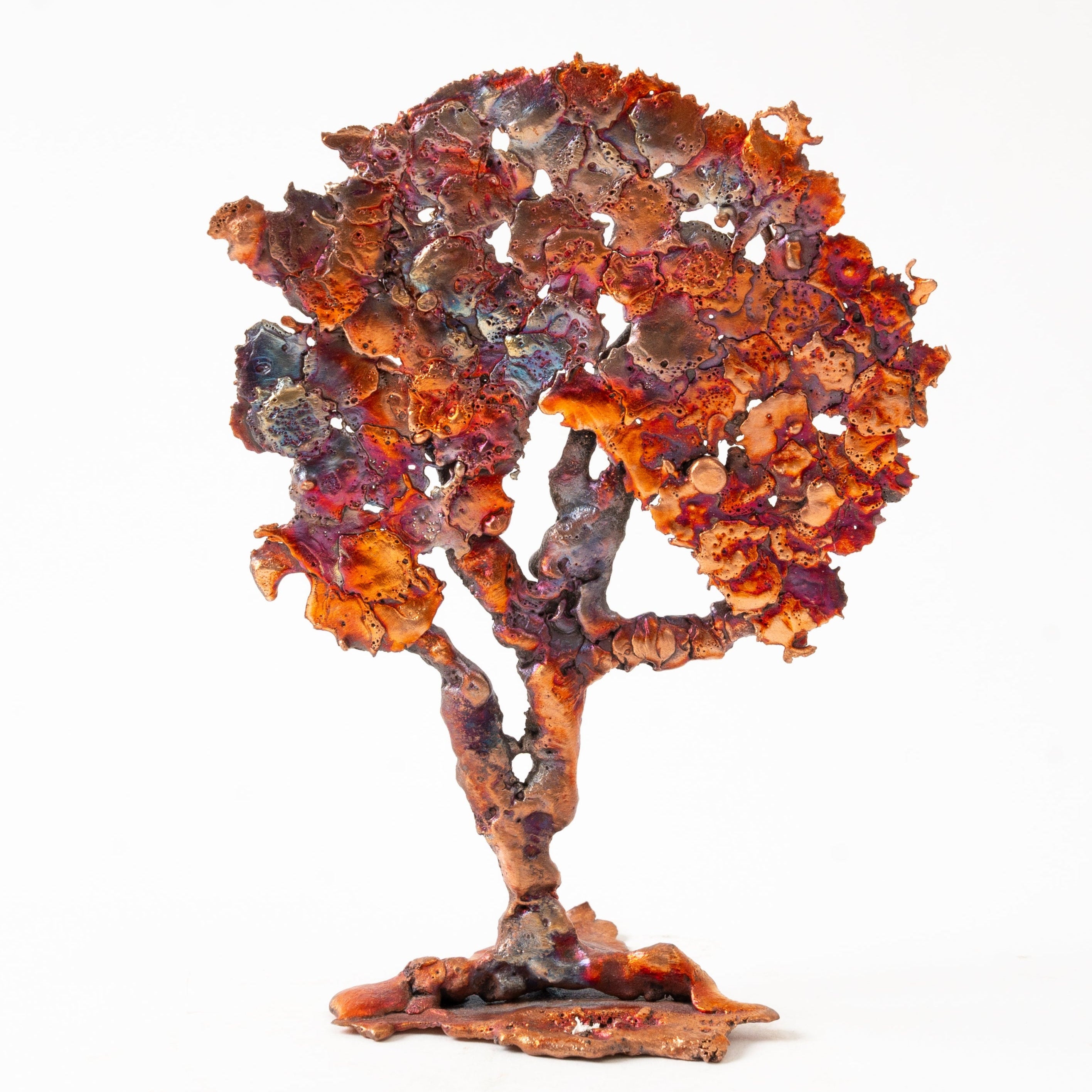 Copper Decorative tree sculpture with rust-like finish on a white background