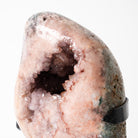 Pink Amethyst Geode crystal with a black band around it on a white background