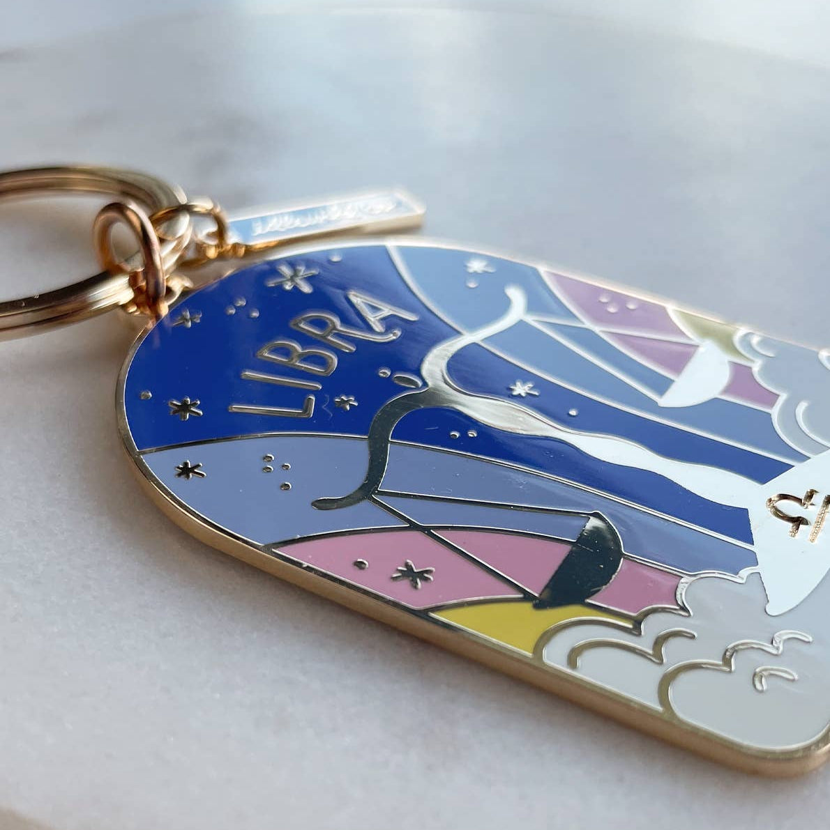 Keychain with Libra zodiac design on a marble surface
