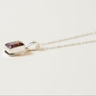 Necklace with a ametrine pendant on a light beige background