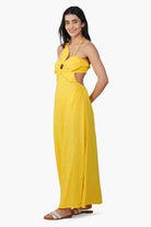 Woman wearing a yellow dress with cut-out design on a white background
