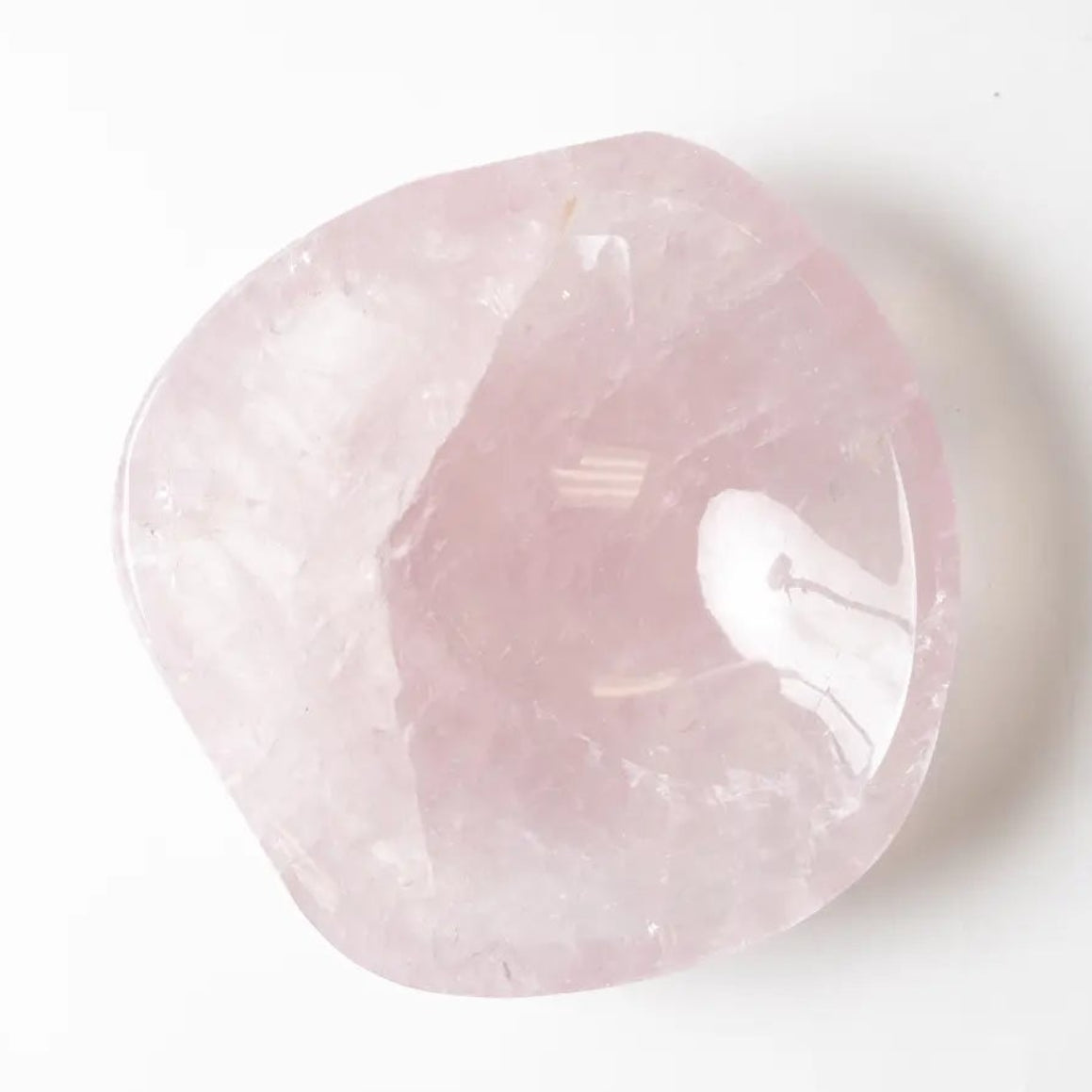 Polished rose quartz crystal on a white background