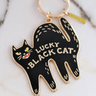 Black cat-shaped keychain with 'Lucky Black Cat' text on a marble surface