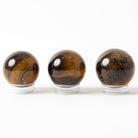 Three tiger eye stones on a white background