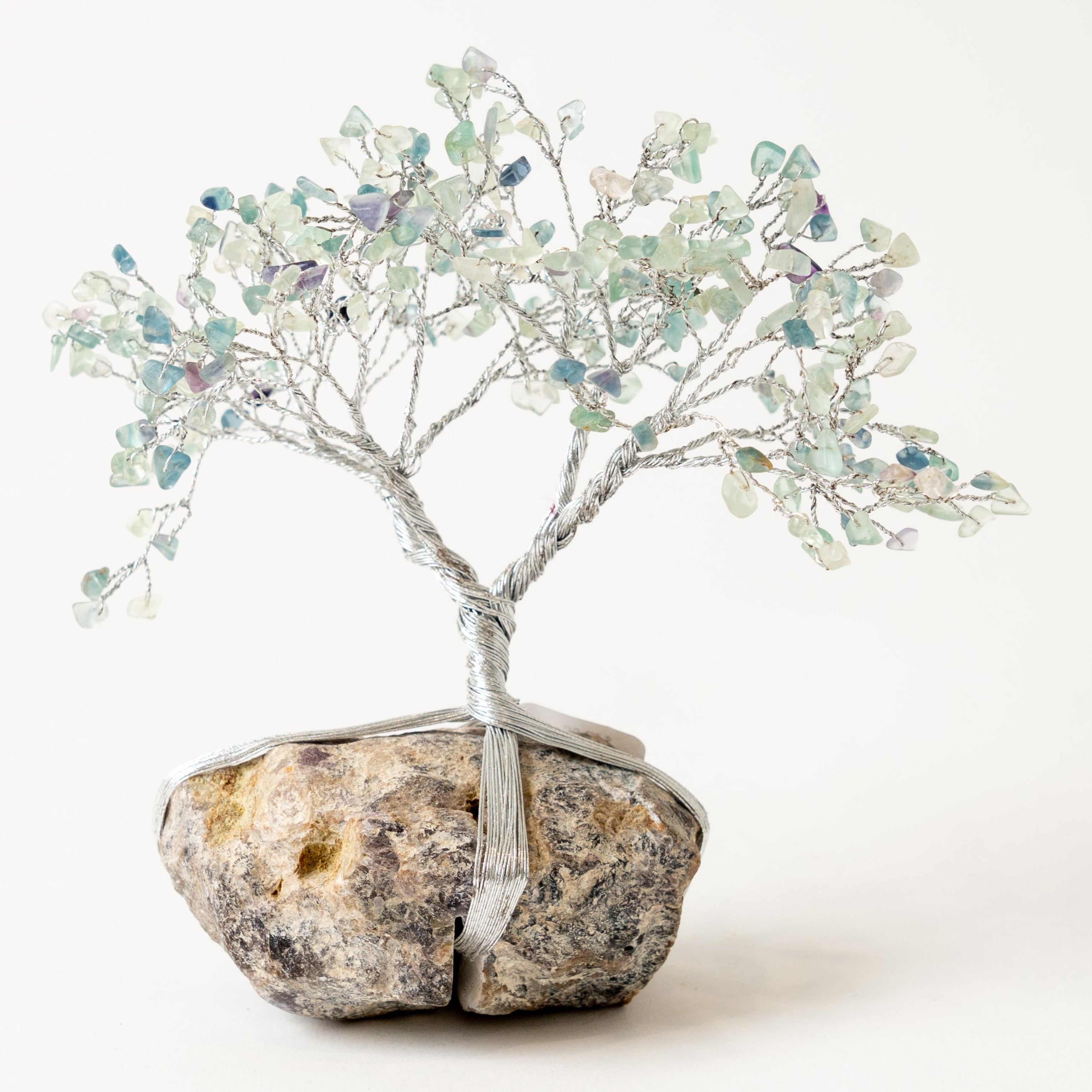 Decorative fluotree with small stones on a rock base against a white backgroundite 