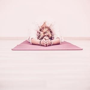 Person in a yoga pose on a pink mat with a pink background