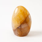 Polished amber-colored Golden Healer stone on a white background