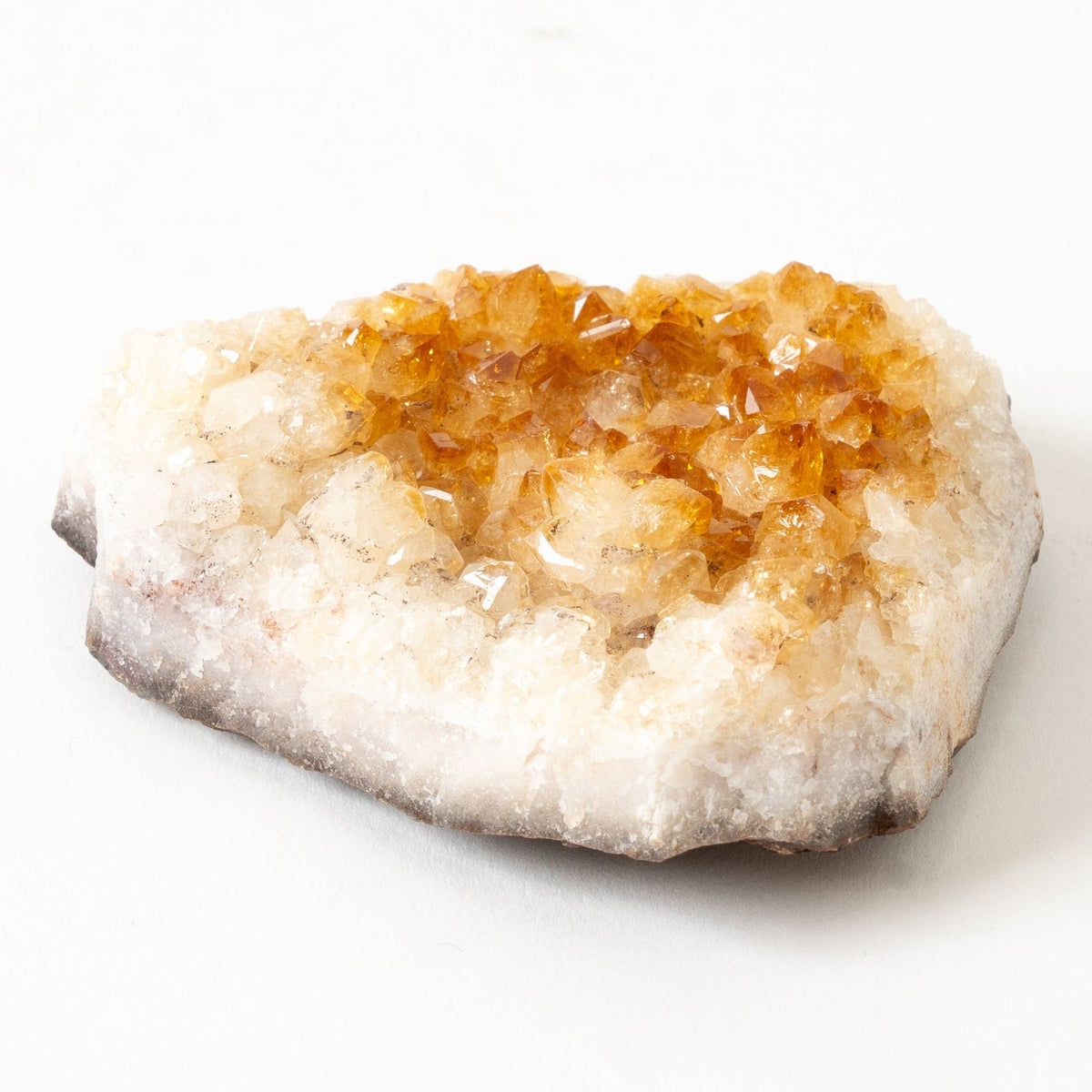 Citrine Geode with amber-colored crystal inside on a white background