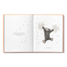 Open book with a bear illustration and text on a white background