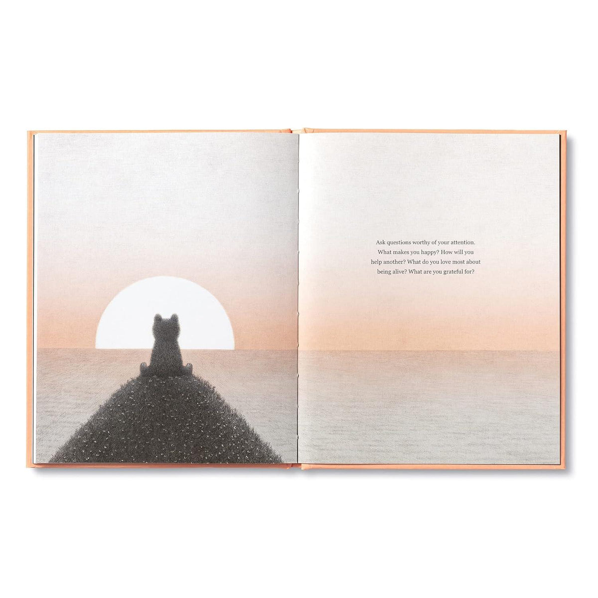 Open book with a silhouette of a person sitting on a mountain at sunset.