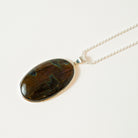Necklace with a large, oval, multicolored stone pendant on a light background