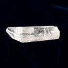 Clear Danburite crystal on a dark blue fabric background