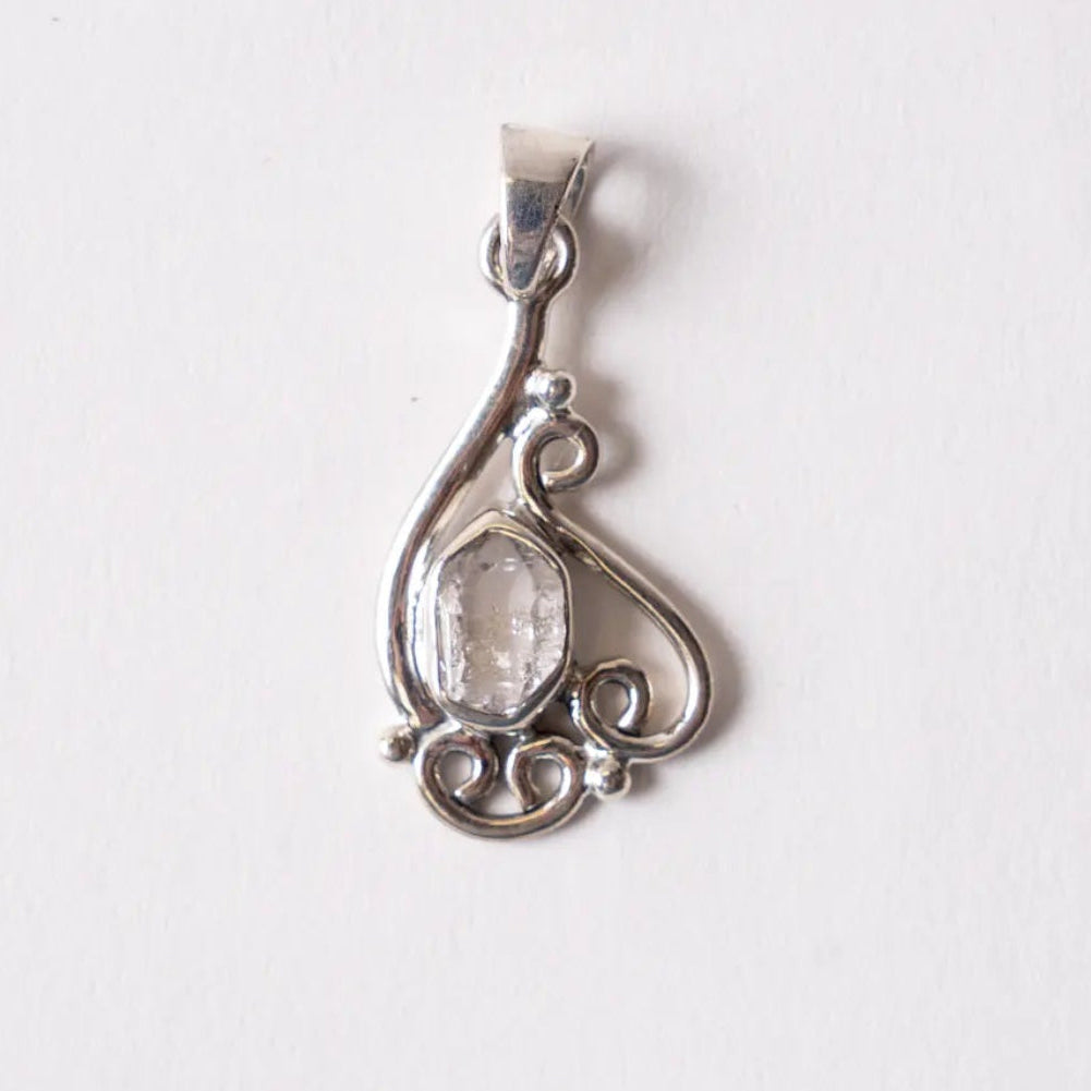 Silver pendant with a clear stone on a white background