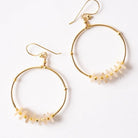 Gold hoop earrings with small stones on a white background