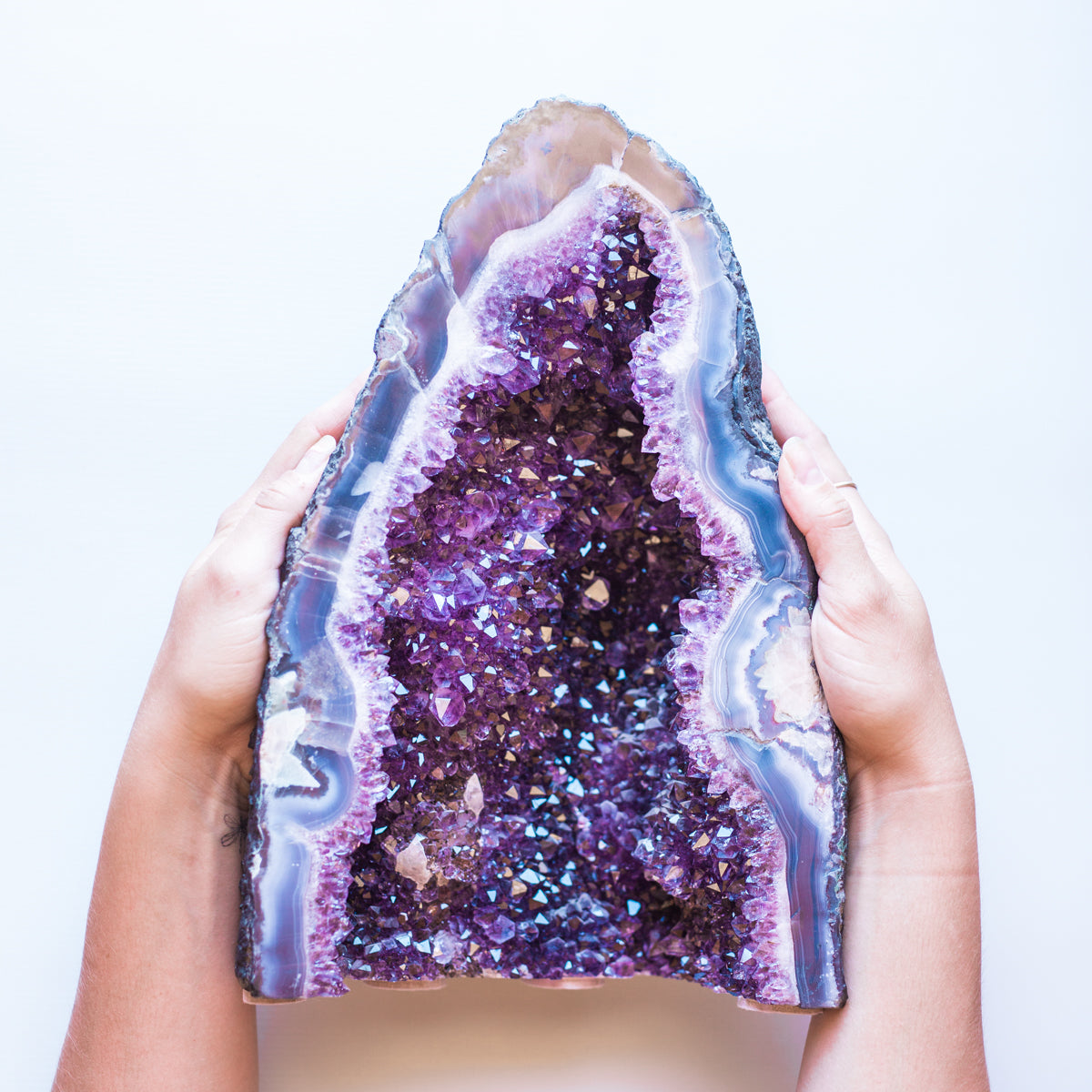 Hand holding an amethyst cluster