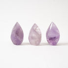 Three flame shaped Amethyst crystals on a white background