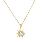 Gold sun-shaped pendant necklace with a central gemstone on a white background