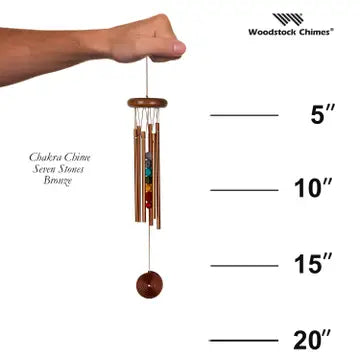 Woodstock Chimes wind chime held by a hand with measurements on a white background