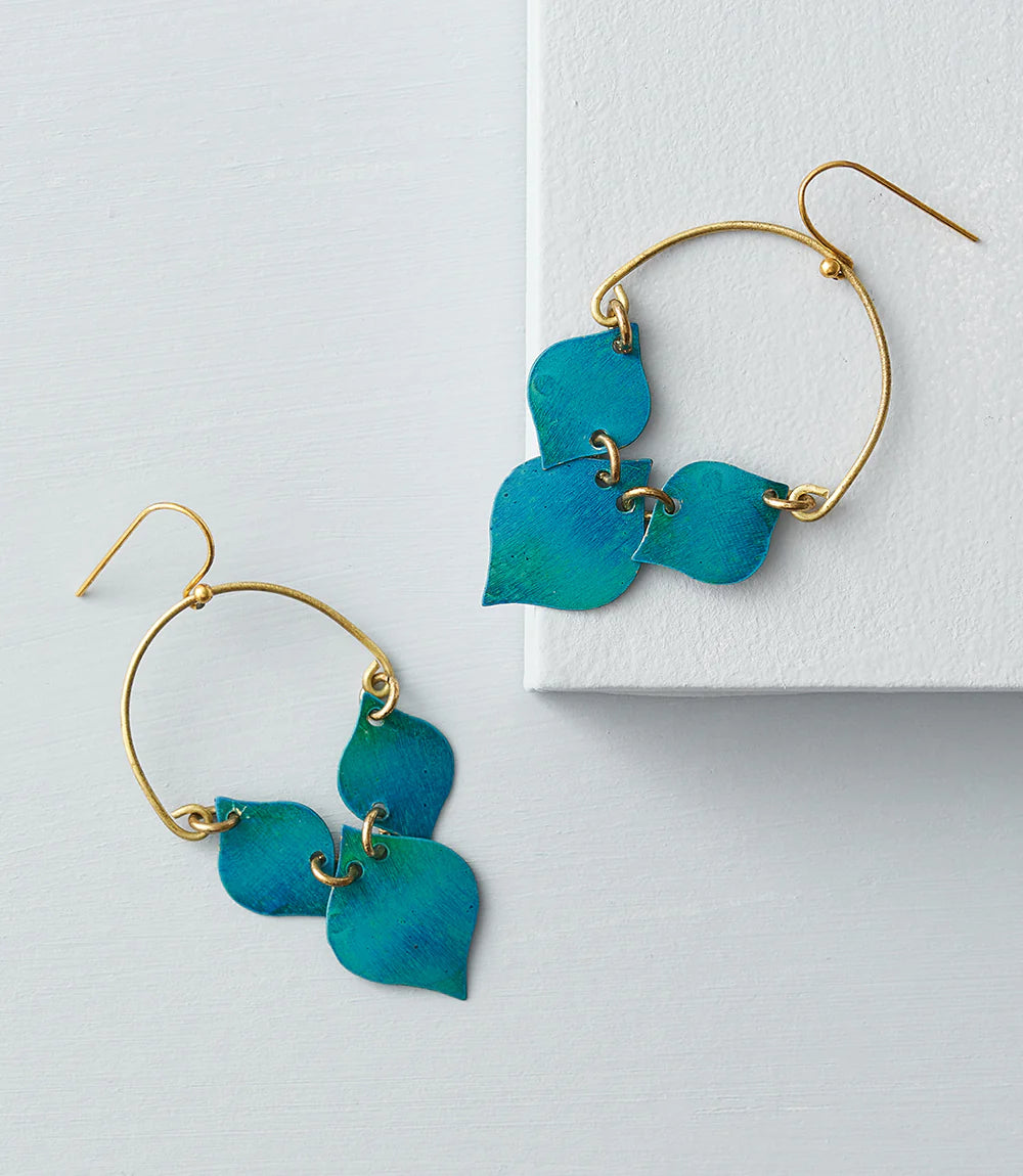 Pair of turquoise leaf-shaped earrings with gold hooks on a light gray background