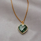 Necklace with a green heart-shaped pendant on a gray background