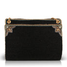 A black beaded clutch purse with gold-tone hardware and decorative corner embellishments, shown against a plain white background.
