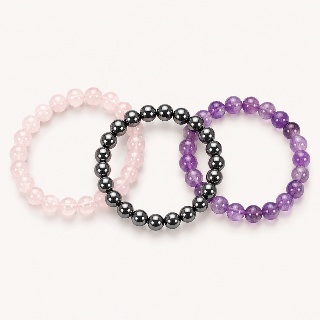 Three beaded bracelets in rose quartz, hematite and purple amethyst on a white background