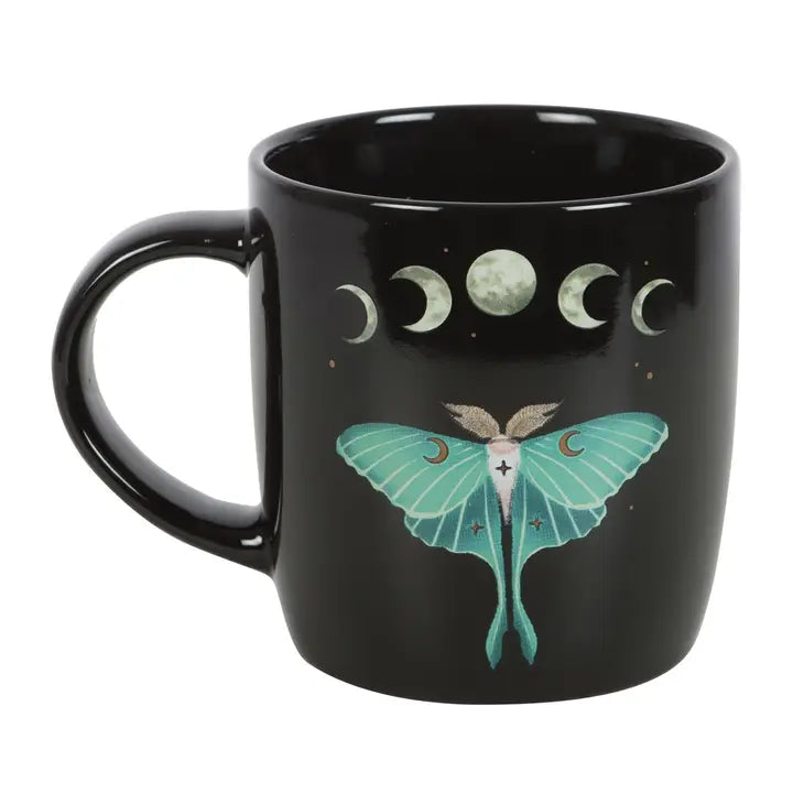 Black mug with a green moth and moon phases design on a white background
