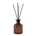Amber glass reed diffuser bottle with black reeds, labeled 'CALM & SERENITY' 