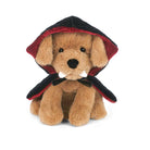 A plush toy dog dressed as a vampire, featuring tan fur, black and red hooded cape, and small white fangs, photographed on a clean white background.