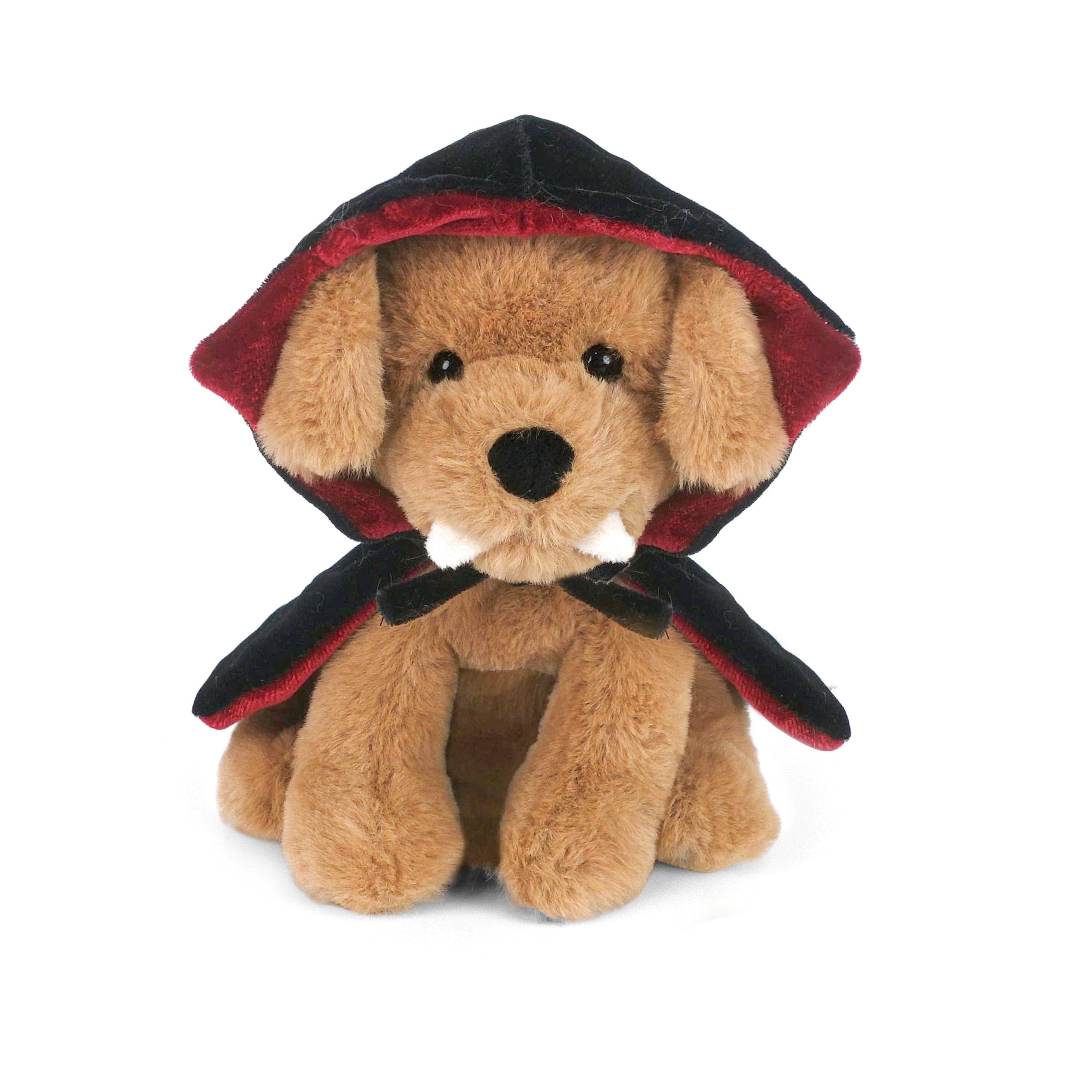 A plush toy dog dressed as a vampire, featuring tan fur, black and red hooded cape, and small white fangs, photographed on a clean white background.