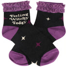 A pair of black ankle socks with purple ruffled cuffs, purple heels and toes, and embroidered details. One sock features the text 'Feeling Witchy Today' in white, while the other has small white and purple star accents.