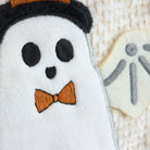 Ghost detail from bag with a bow tie on a textured surface 