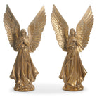 Two gold angel statues with outstretched wings on a white background