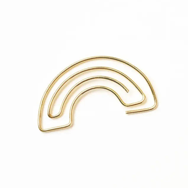 Gold rainbow-shaped paper clip on a white background