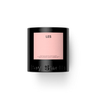 Les Black candle with a pink label on a white background