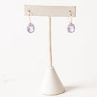 Pair of Lavender Quartz earrings on a white stand with a white background