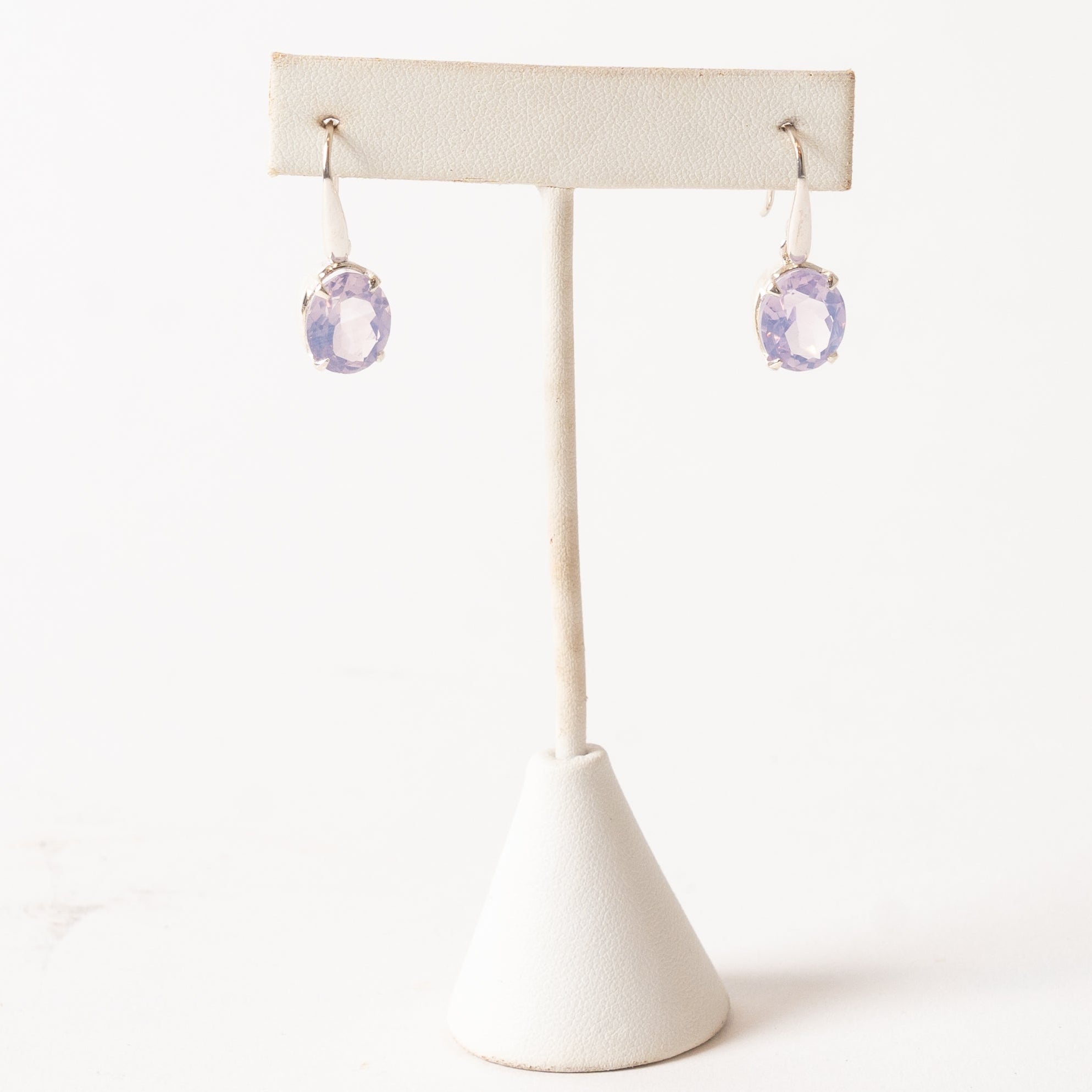 Pair of Lavender Quartz earrings on a white stand with a white background