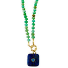 A beaded necklace featuring a strand of amazoite  beads with a gold-tone clasp and a square dark blue lapis lazuli pendant with a small heart-shaped blue inlay.
