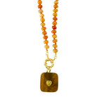 A beaded necklace featuring round orange and yellow red aventurine beads on a gold-tone chain, with a rectangular brown tiger's eye pendant and a small gold heart detail, shown against a plain white background.