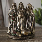 Decorative figurine of three hooded figures on a wooden surface