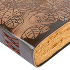 Close-up of a leather-bound book with embossed design and stitching detail.