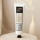 Tube of Archipelago Botanicals Oat Creme Milk on a beige surface