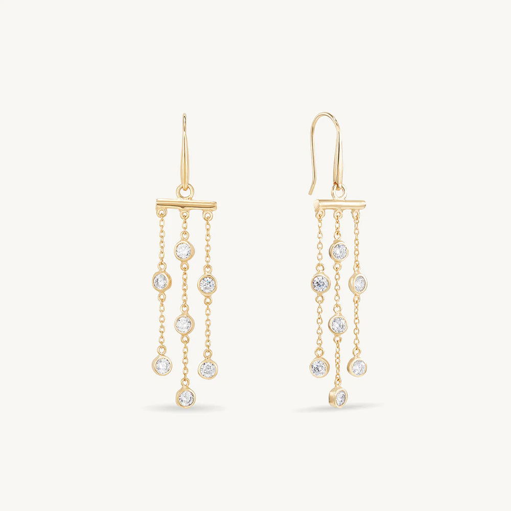 Gold earrings with cubic zirconia drops on a white background