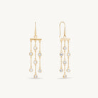 Gold earrings with cubic zirconia drops on a white background