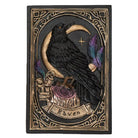 A gothic-style carved plaque featuring a black raven perched on a crescent moon above a rose, with purple feathers and the word 'Raven' on a banner, set against a dark background with ornate gold detailing.