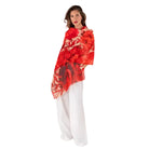Woman wearing a red floral top and white pants on a white background