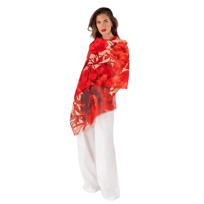 Woman wearing a red floral top and white pants on a white background
