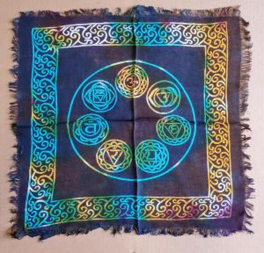 Colorful chakra symbol on a blue fabric square with intricate patterns.