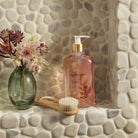 Sienna Sage Body Wash in a background of stones with flowers