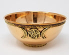 Copper bowl with pentacle and moon designs on a white background